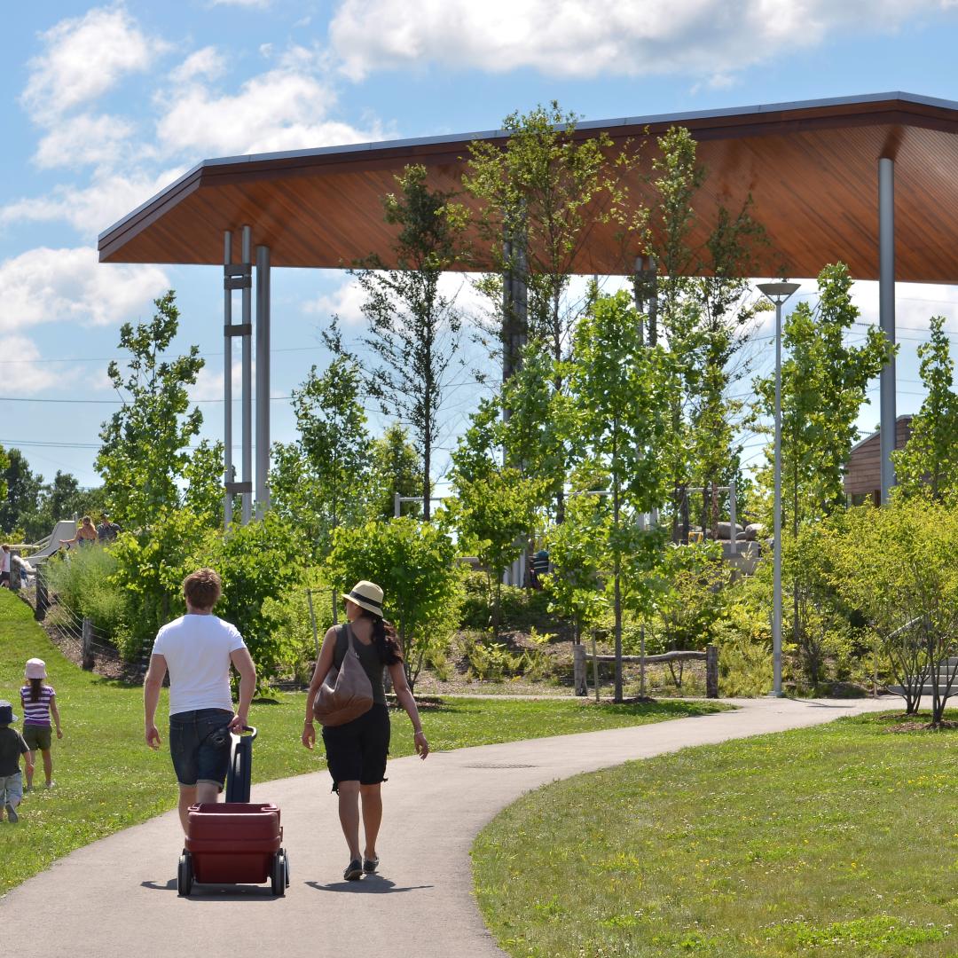 people enjoying a sunny day and walking along the paths at Corktown Common