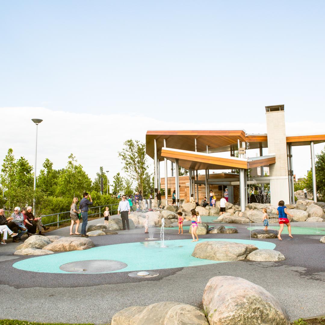 families enjoying the splash pad on a sunny summer day