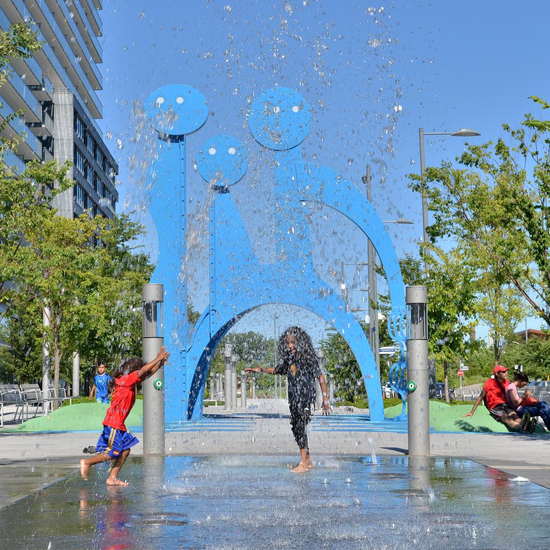 children running through a splash pad