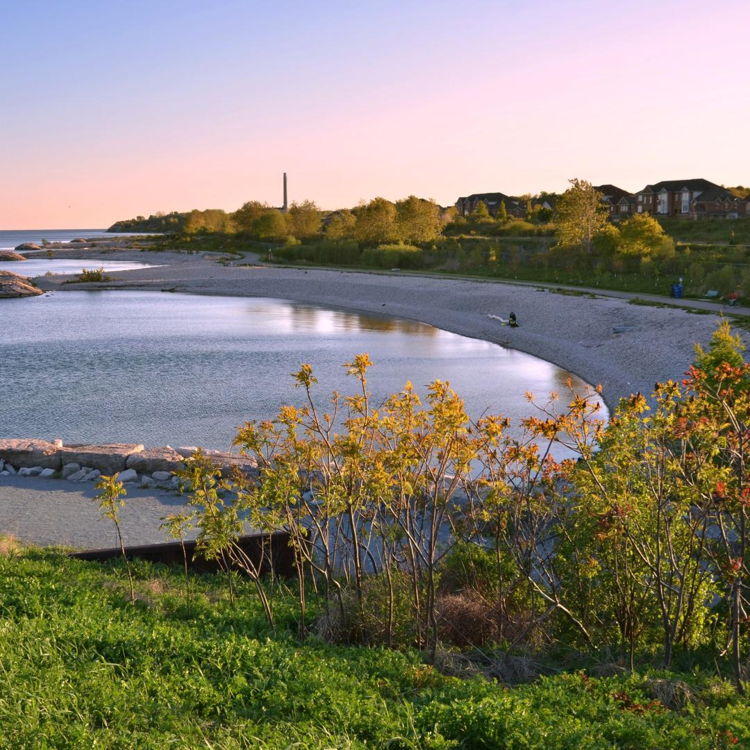 a view of the shoreline and cobblestone beach at dusk