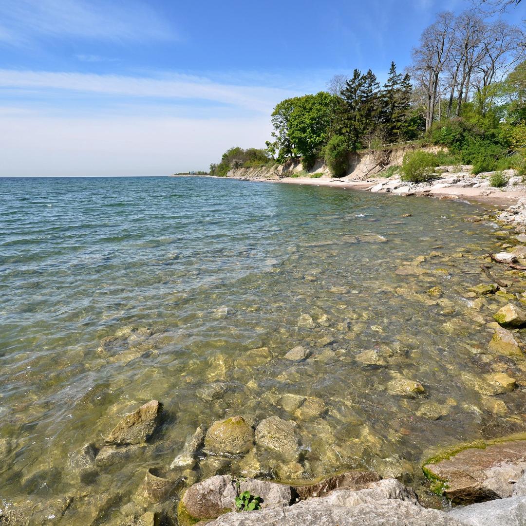 cobblestone beaches on a sunny day with Lake Ontario in the background