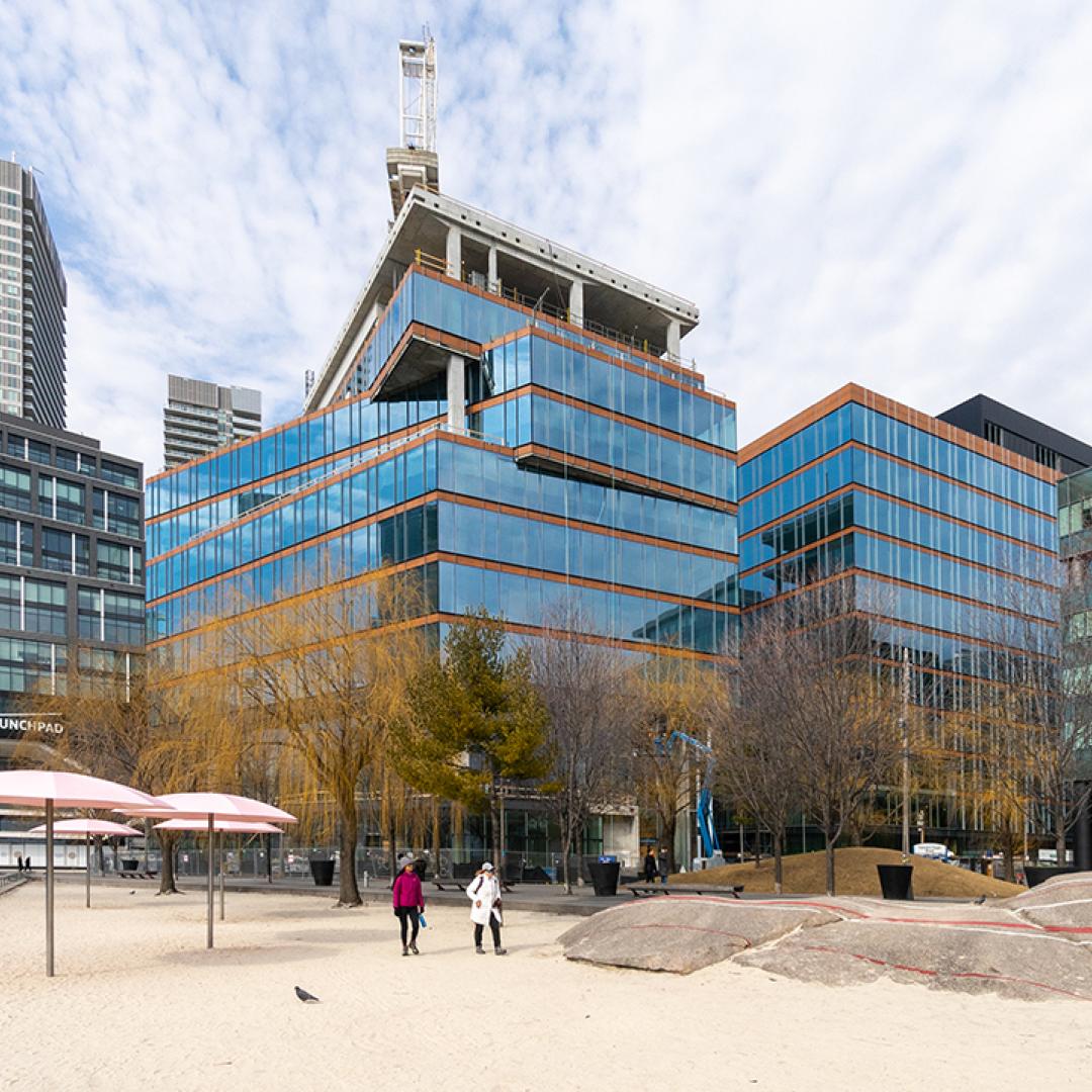 A photo showing the exterior of a building next to an urban beach