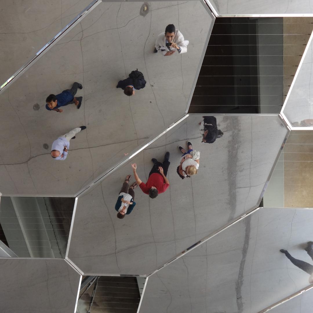 a mirrored public art installment showing people's reflections from up above