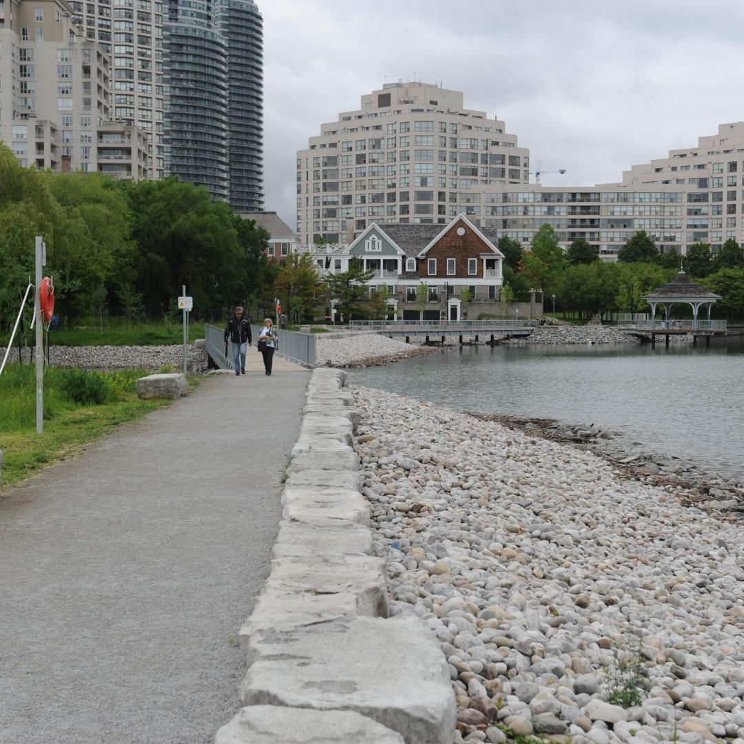 a waterfront trail next to Lake Ontario with condo buildings in the background