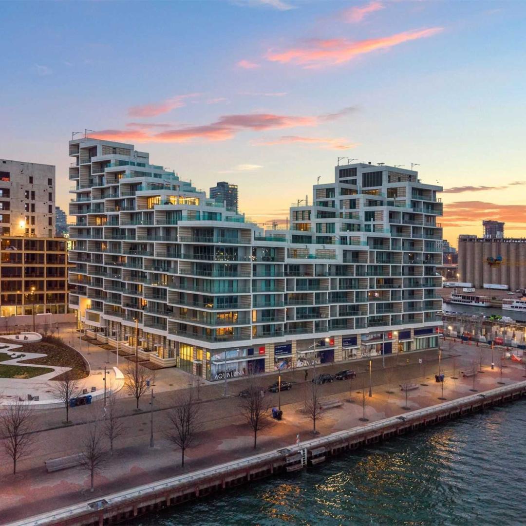 Rendering: a waterfront apartment building at sunrise.