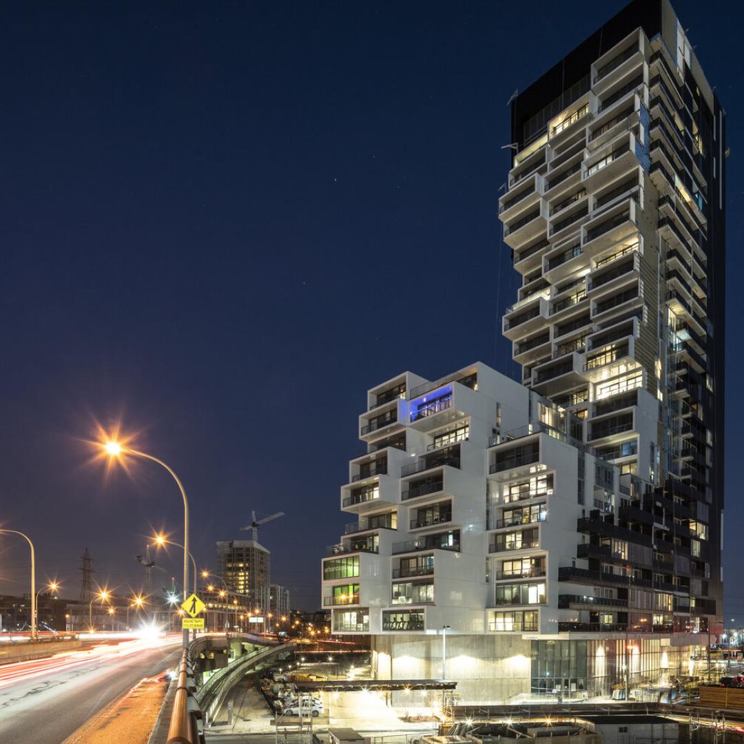 An apartment tower at night in a downtown. 