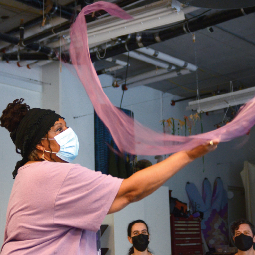 close-up of a performer swinging a pink ribbon in the air