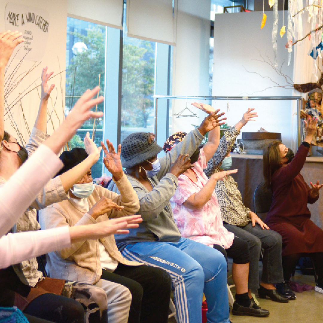people seated with their hands in the air