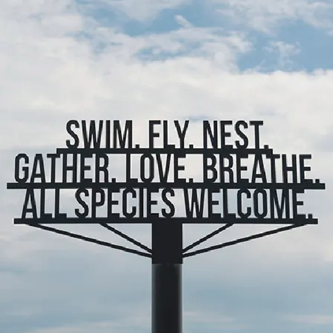 metal sign that reads: swim. fly. nest. gather. love. breathe. all species welcome.