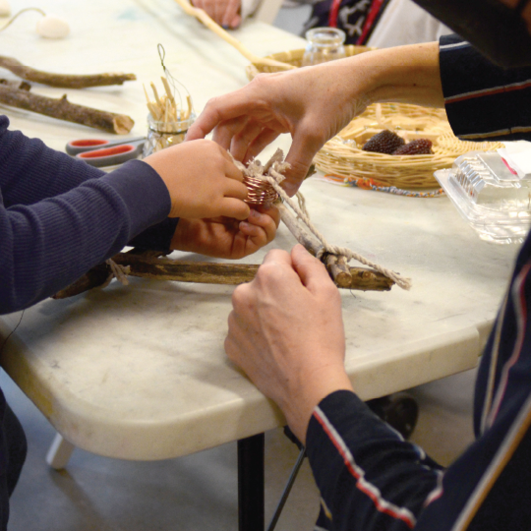 two people at a table making sculptures