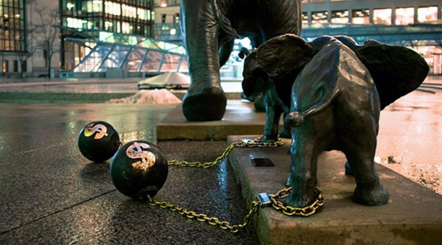 a statue of two elephants with a ball and chain