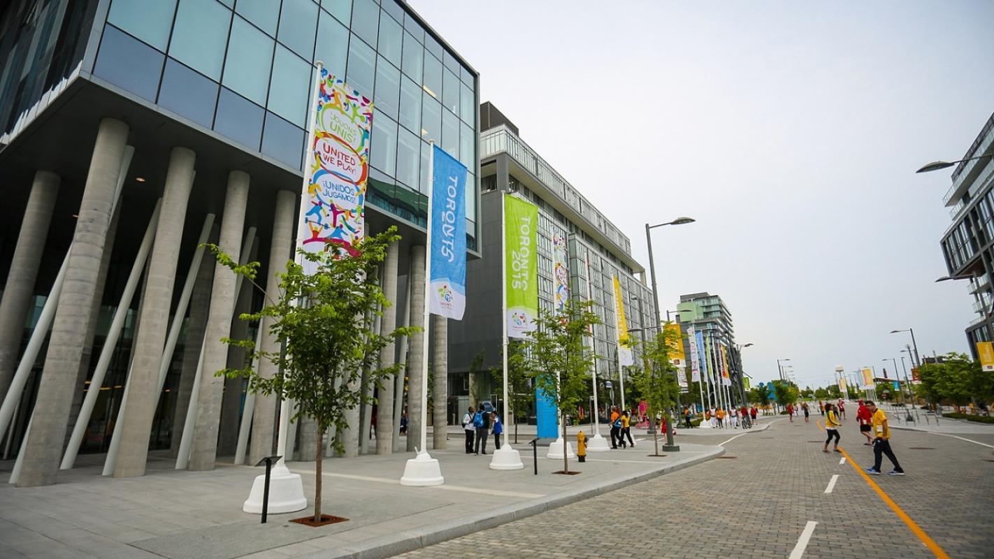 people walking outside buildings next to large street banners