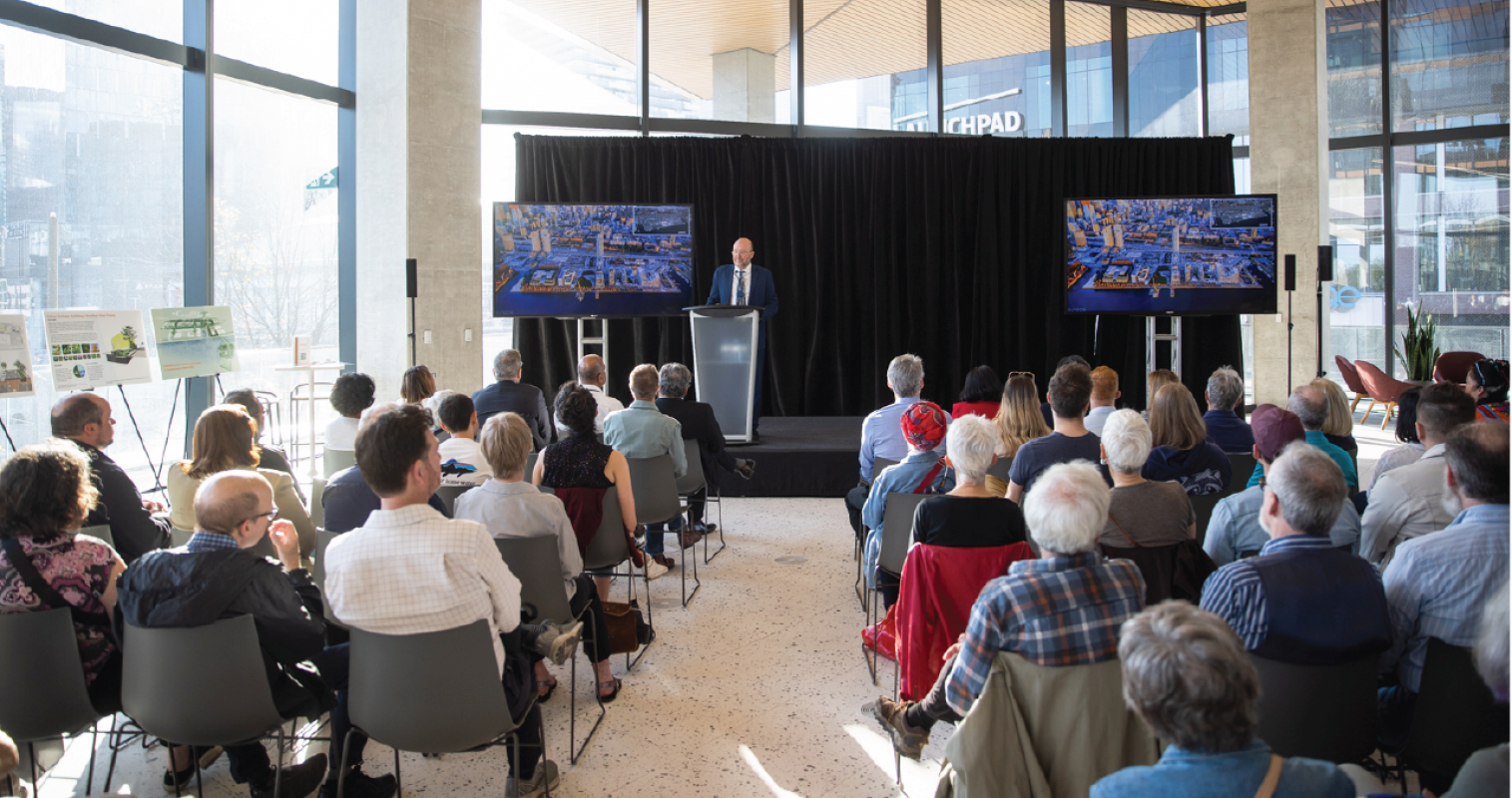 A seated audience facing a person on a podium.