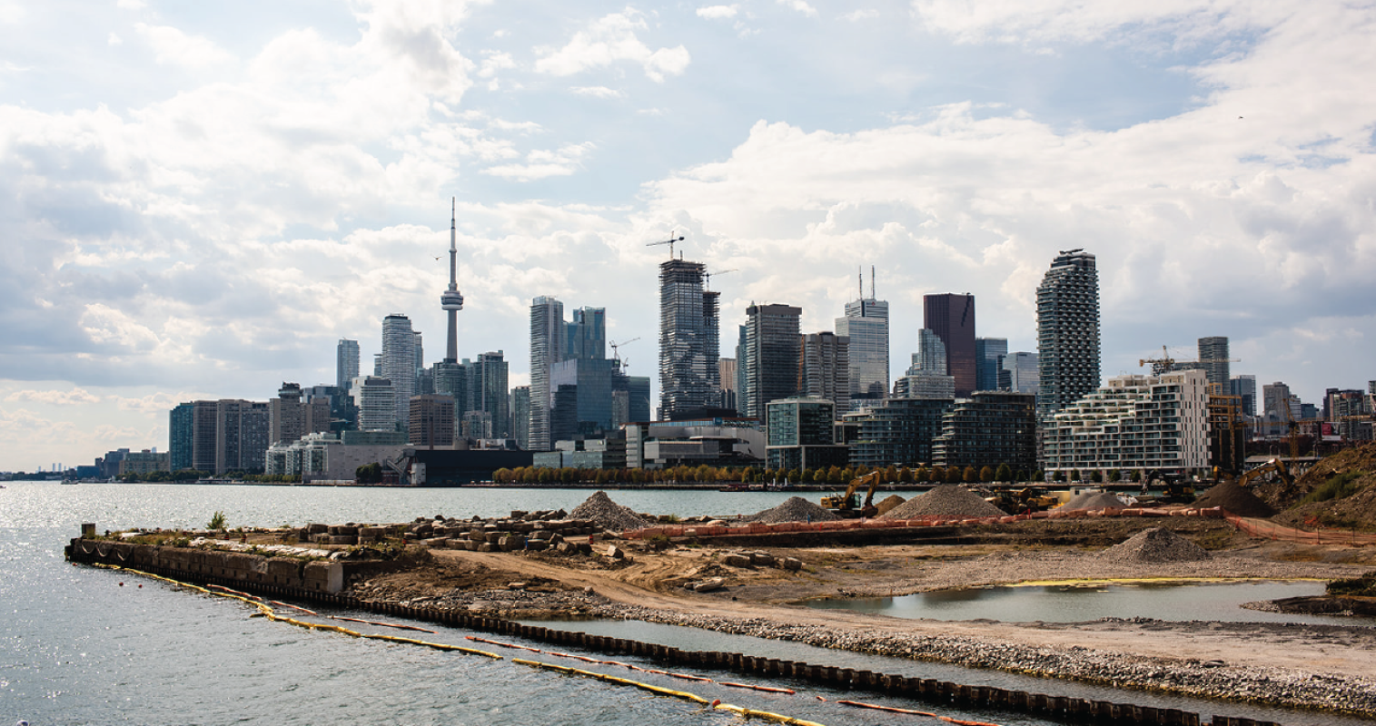 A waterfront construction site with Toronto's skyline in background. 