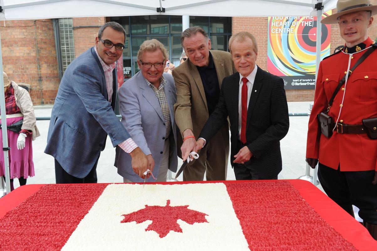 four men cutting a large Canada flag cake