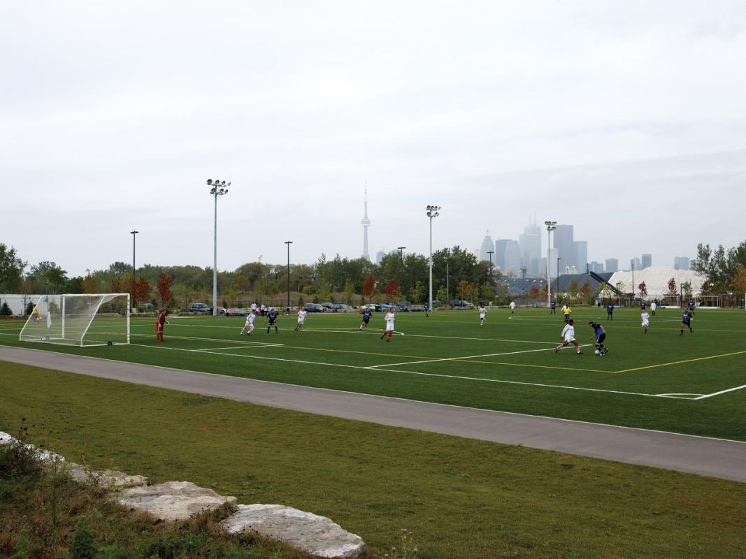 people playing a game of soccer on new green fields