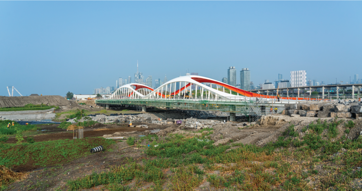 An arched bridge with Toronto's downtown skyline in background. 