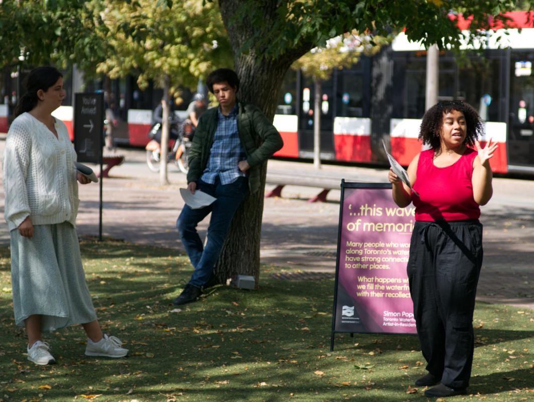 Three actors performing in a park.