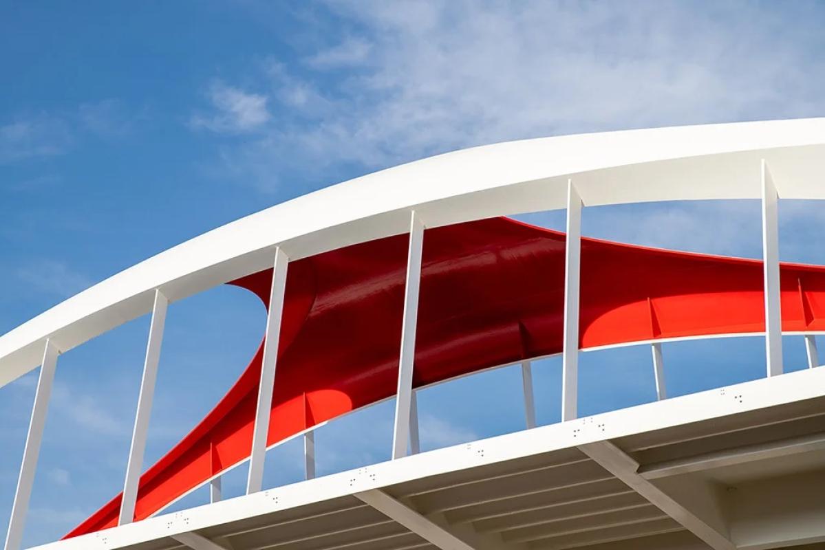 looking up at a red and white bridge and blue sky