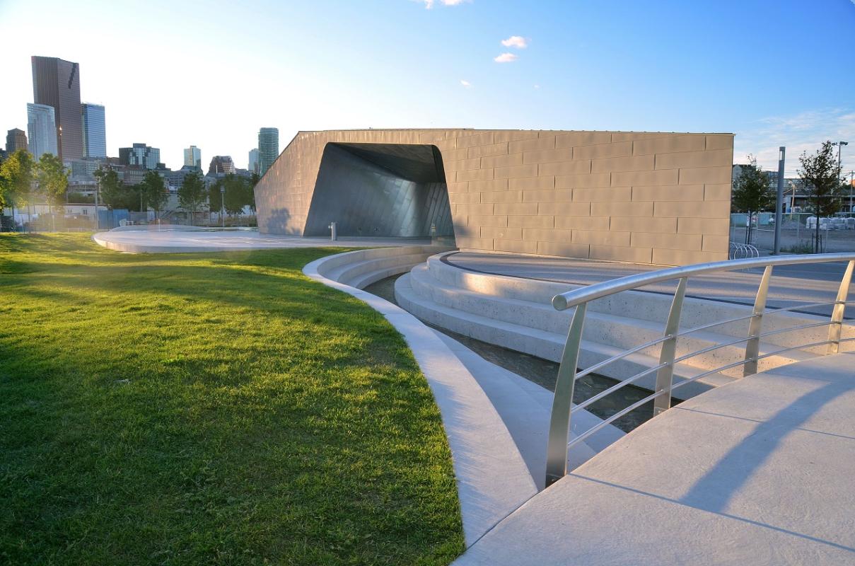 a zinc-clad structure acts as a park's pavilion next to open green space