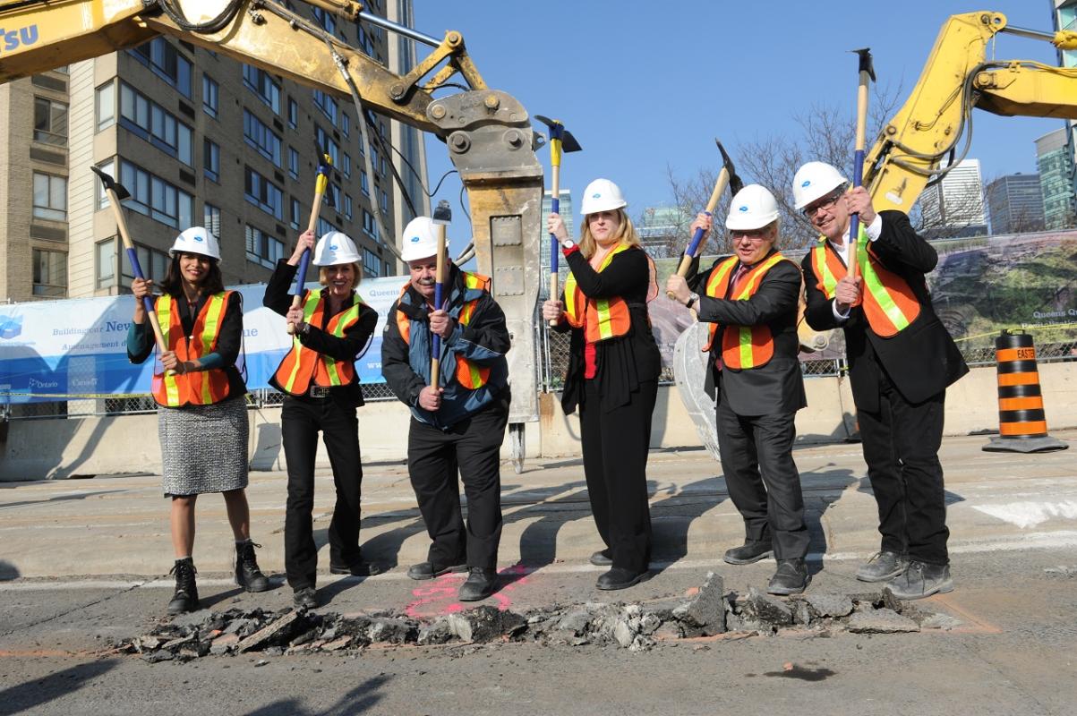 a group of people in PPE posing for a photo at a groundbreaking event