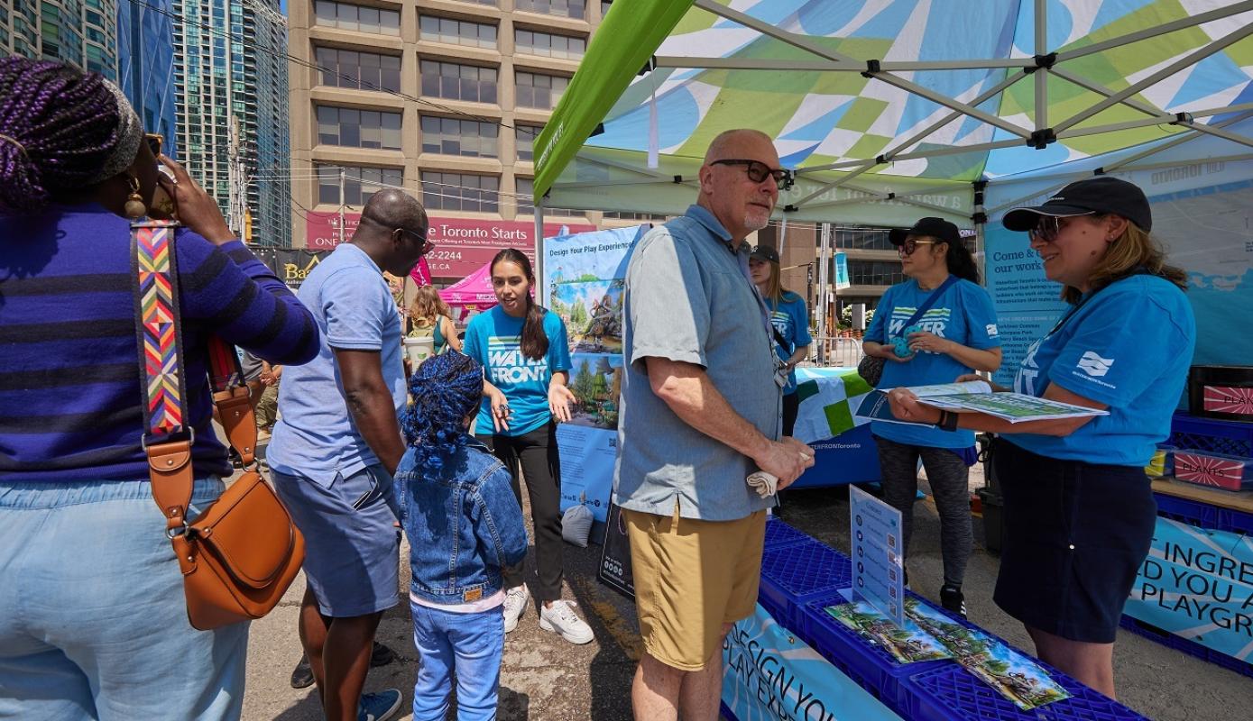 people speaking to staff at a waterfront event