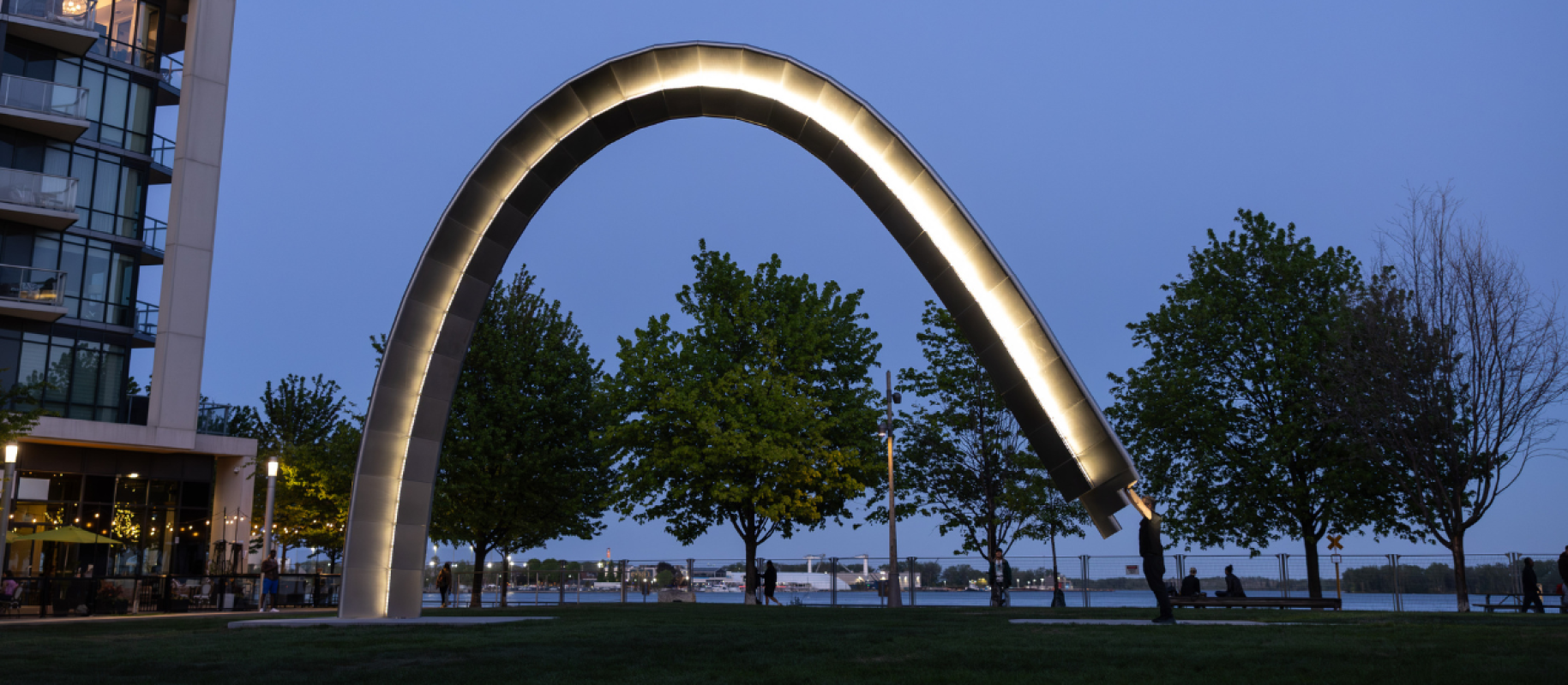 A large public art arch is activated by the artist and lit up at night