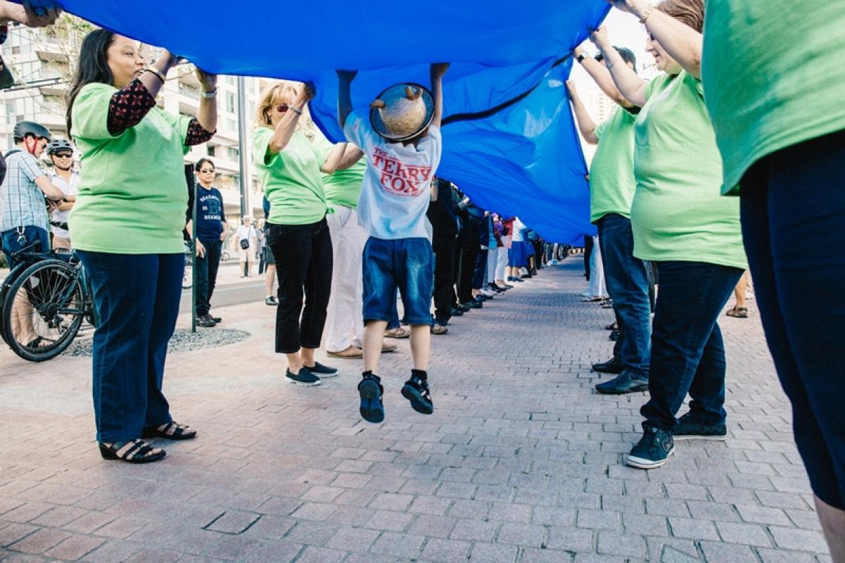 Community members wave a 650-metre long blue ribbon to celebrate the grand opening of the newly revitalized Queens Quay.