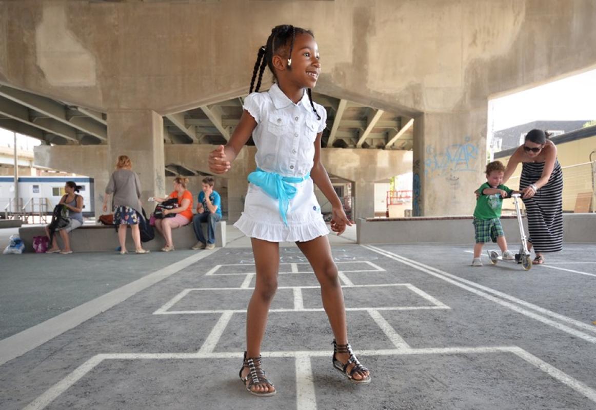 Kids playing at the hopscotch court at Underpass Park. 