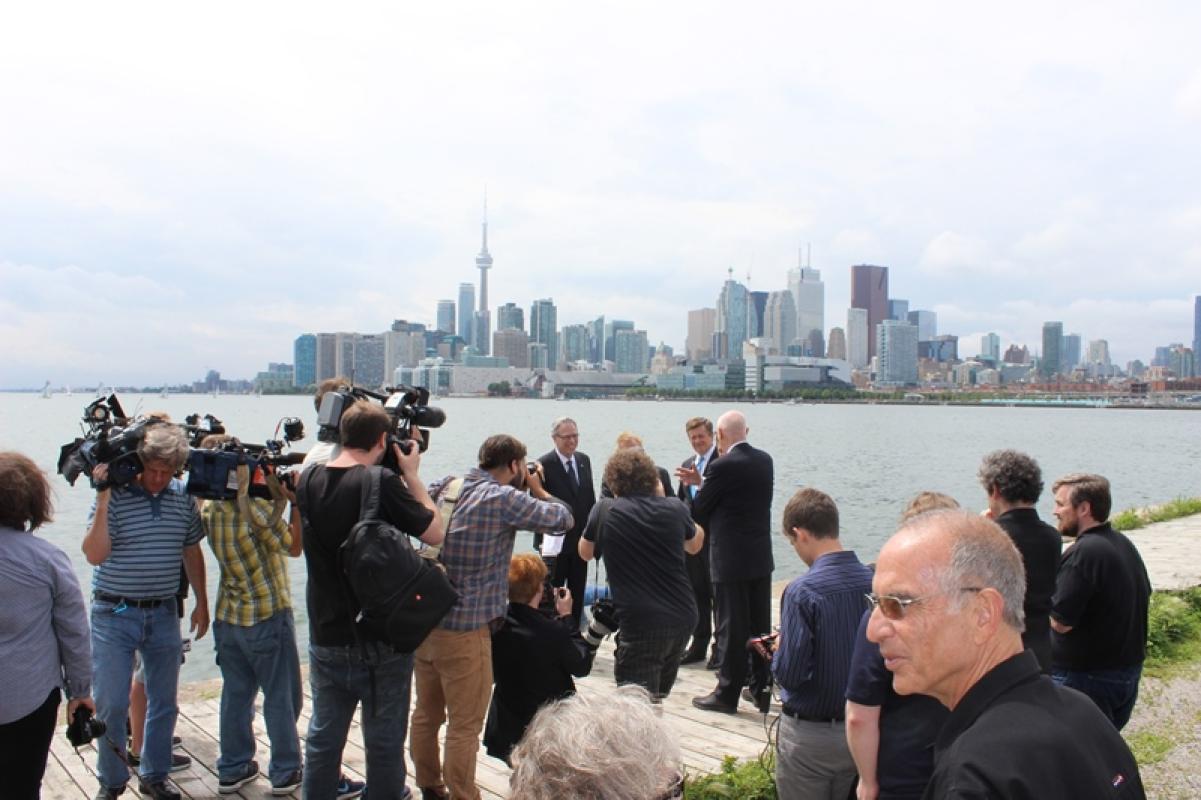 Representatives from Waterfront Toronto and all three orders of government stand at the water’s edge where the proposed re-aligned Don River would connect with Lake Ontario.