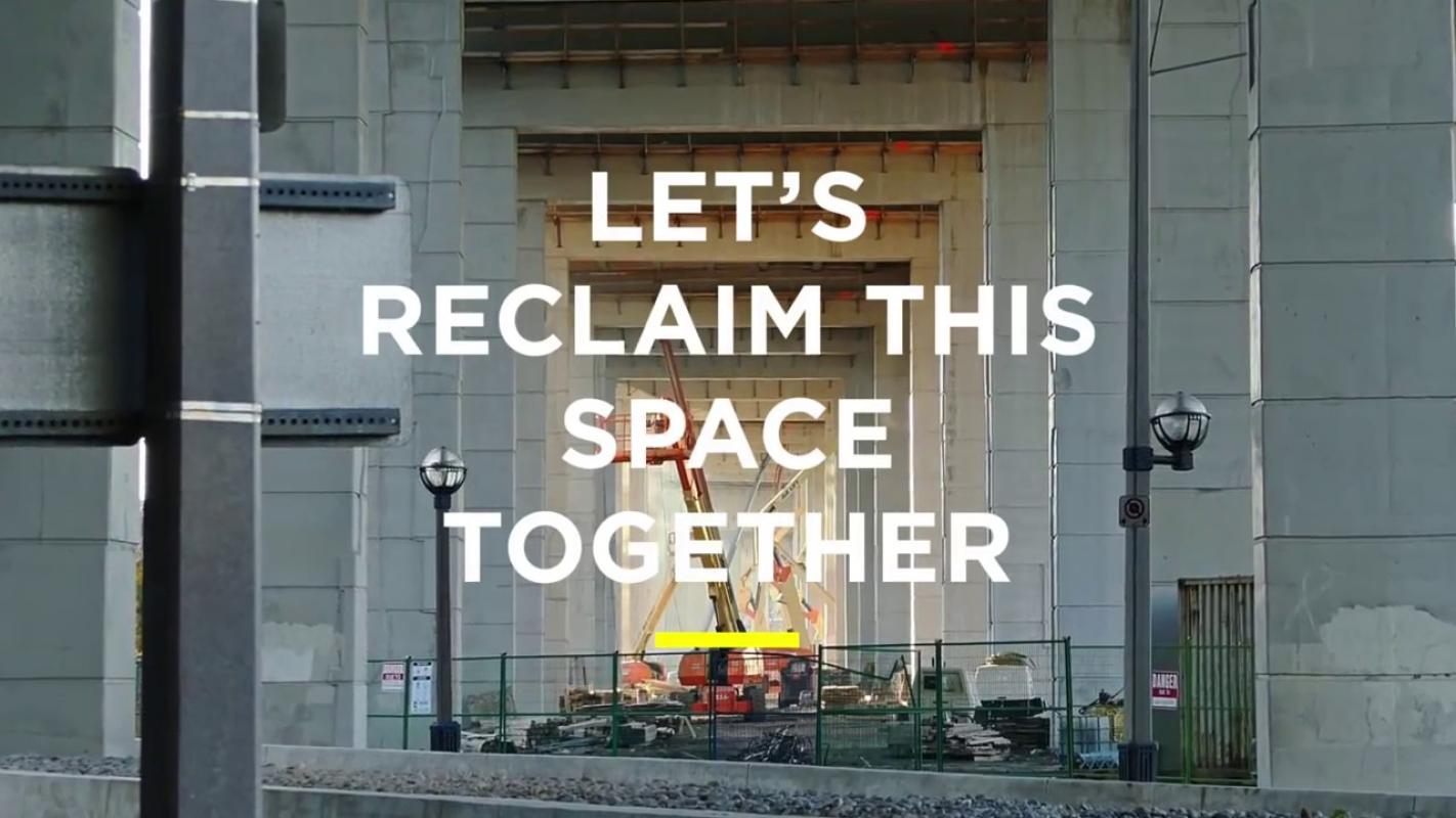 Image description: Looking through the the columns supporting the Gardiner Expressway, there is an active construction site in the background. Block text reads "Let's Reclaim This Space Together."