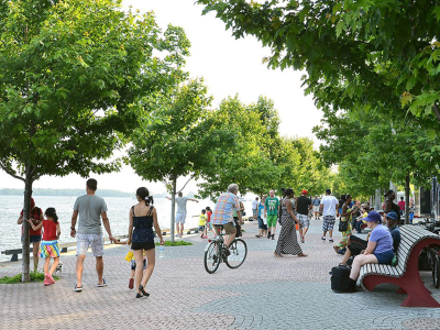 image of people on bikes and walking on boardwalk beside water