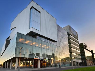 A photo taken at dusk showing the outside of the George Brown College building with the school logo