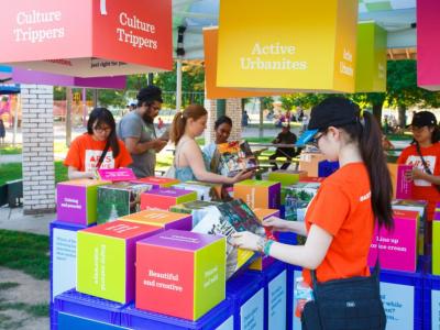 groups of people gathered around colourful milk crates