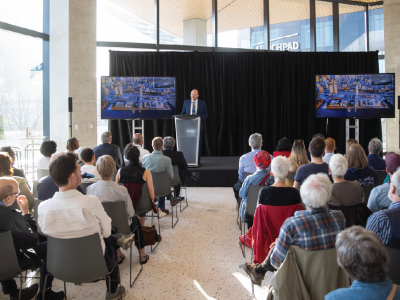 A seated audience facing a person on a podium.