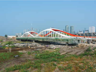 An arched bridge with Toronto's downtown skyline in background. 