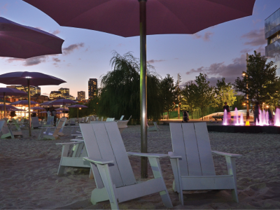 Illuminated pink umbrellas at Cherry Beach at night. 