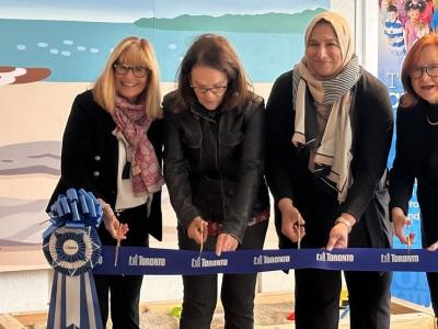four women cutting the ribbon at an opening celebration
