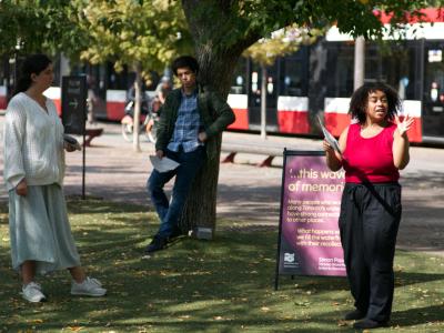 Three actors performing in a park.