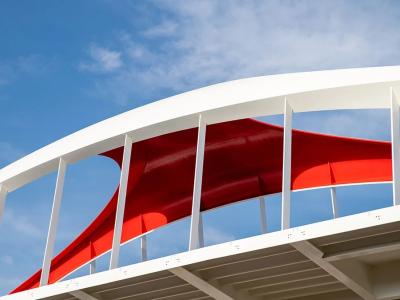 looking up at a red and white bridge and blue sky