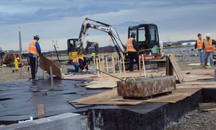 Construction crews working with equipment along the waterfront