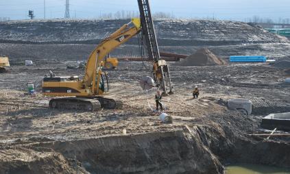 a large active construction site with equipment and crews