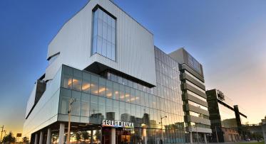 A photo taken at dusk showing the outside of the George Brown College building with the school logo