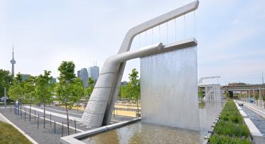 public art structures at Sherbourne Common which have water cascading down into the water channel and the city and CN Tower in the background