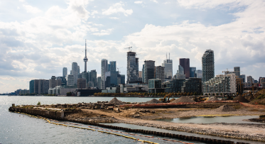 A waterfront construction site with Toronto's skyline in background. 