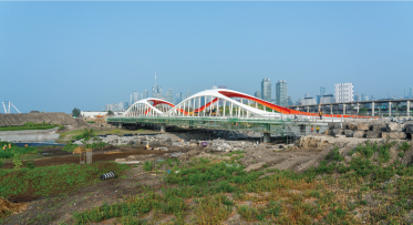 An arched bridge with Toronto's downtown skyline in background. 