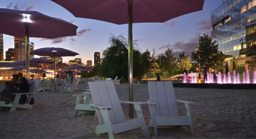 Illuminated pink umbrellas at Cherry Beach at night. 