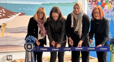 four women cutting the ribbon at an opening celebration