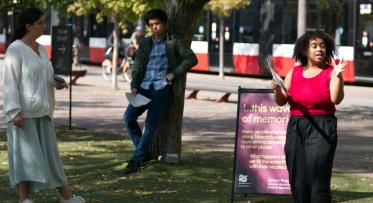 Three actors performing in a park.