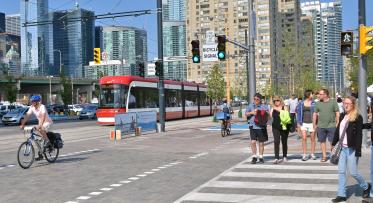 a busy intersection with pedestrians, cyclists and transit users